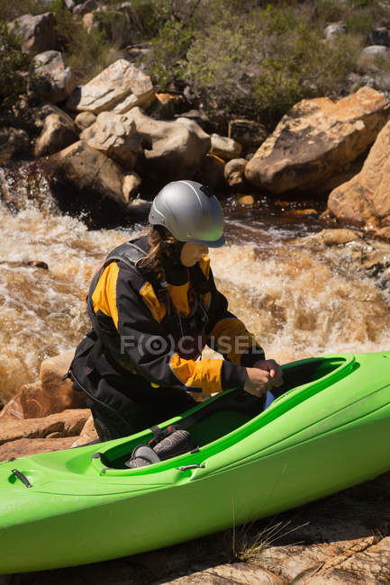 Mujer de pie con bote de kayak por el flujo de agua del río . - foto de stock