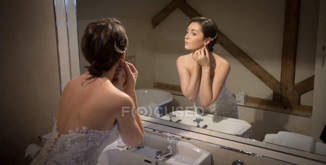 Невеста готовится перед зеркалом дома — стоковое фото
