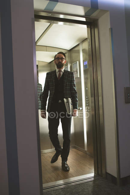 Geschäftsmann kommt aus Aufzug von Hotel — Stockfoto