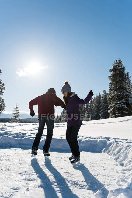Пара катающихся на коньках в снежном ландшафте зимой . — стоковое фото