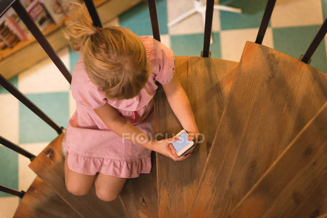 Hochwinkelaufnahme von Mädchen mit Handy im Treppenhaus — Stockfoto