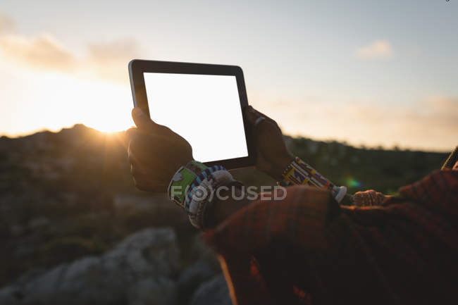 Масаї людина в традиційному одязі, використовуючи цифровий планшетний в сільській місцевості — стокове фото