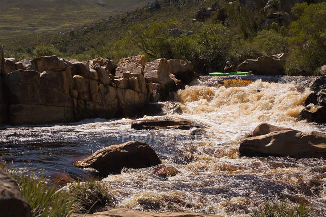 Mulher de caiaque na água do rio da montanha à luz do sol . — Fotografia de Stock