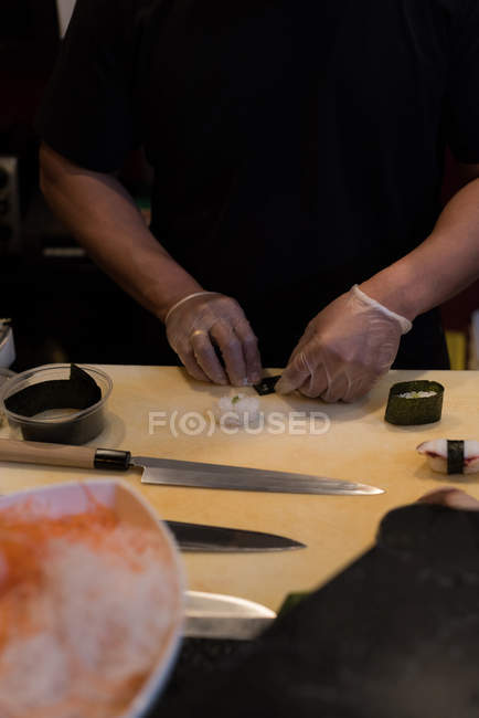 Chef roulant sushi déroulé dans une cuisine de restaurant — Photo de stock