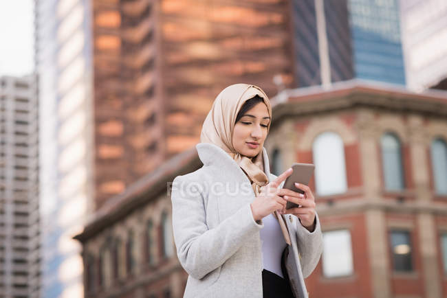 Frau im Hidschab benutzt Handy in der Stadt — Stockfoto