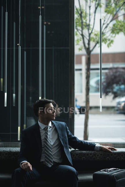 Uomo d'affari premuroso seduto sul divano in hotel — Foto stock