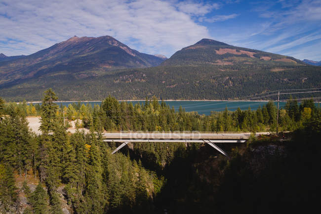 Schmale Brücke, die die Berge durch den Wald verbindet — Stockfoto