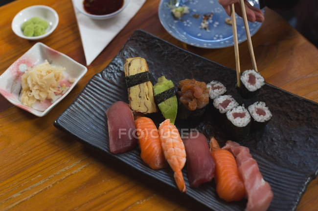Close-up of woman having sushi food in restaurant — Stock Photo