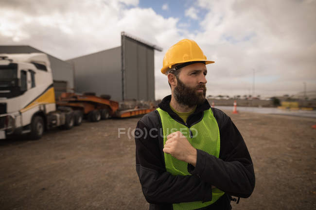 Lavoratore portuale riflessivo in piedi nel cantiere navale — Foto stock