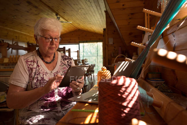 Donna anziana attiva utilizzando tablet digitale presso il negozio — Foto stock
