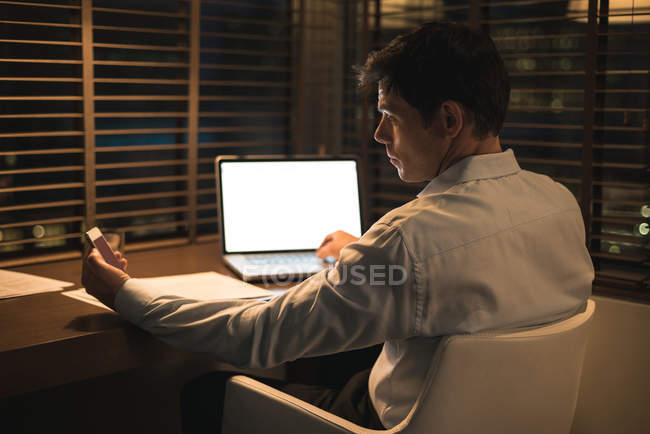 Businessman using digital tablet and mobile phone in hotel — Stock Photo
