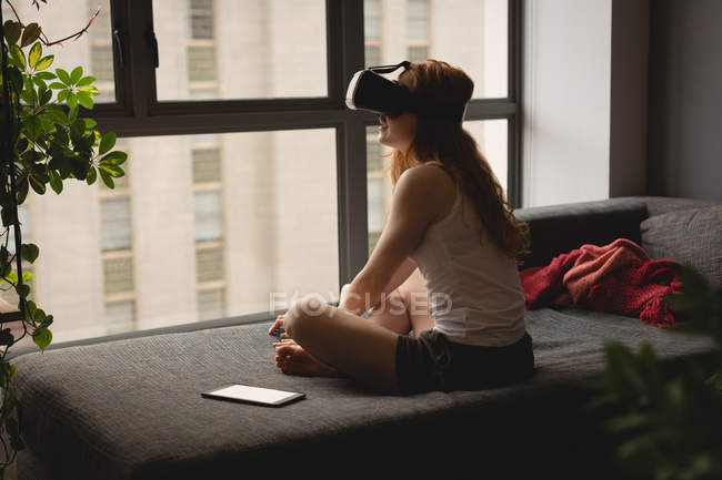 Mujer usando auriculares de realidad virtual en casa - foto de stock