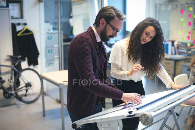 Executives discussing over blueprint in modern office — Stock Photo
