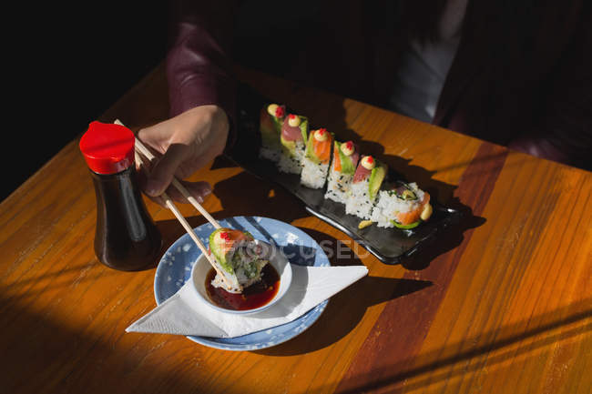 Gros plan de la femme ayant de la nourriture sushi au restaurant — Photo de stock