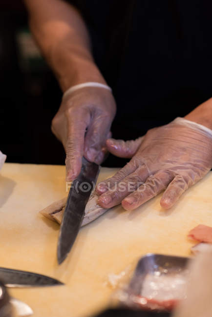 Chef filleting fish in the restaurant kitchen on a chopping board — Stock Photo