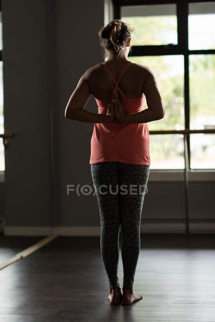 Rückansicht einer Frau, die Yoga im Fitnessstudio praktiziert. — Stockfoto