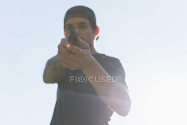 Homem atirando com arma em um dia ensolarado — Fotografia de Stock