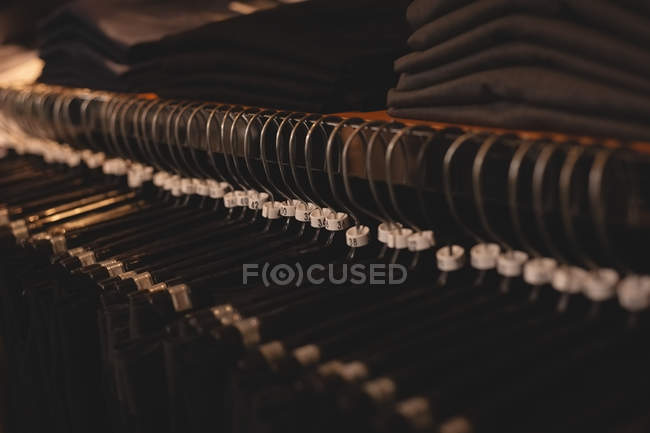Primer plano de la percha de ropa arreglada en rack - foto de stock