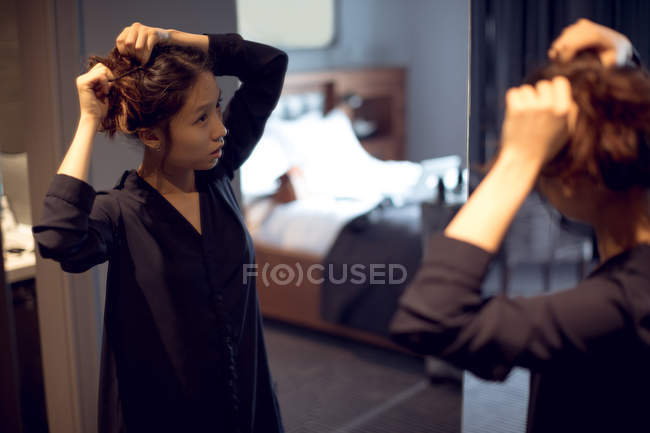 Frau macht sich im Hotel vor dem Spiegel fertig — Stockfoto