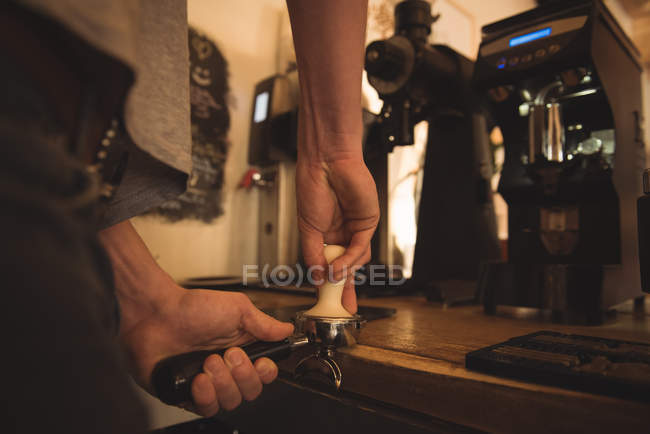 Partie médiane du barista préparant le café au comptoir de la cafétéria — Photo de stock