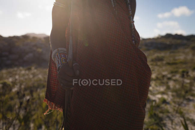 Mid section of maasai man standing at countryside on a sunny day — Stock Photo