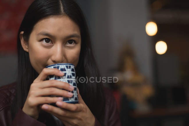 Junge Frau trinkt grünen Tee im Restaurant — Stockfoto