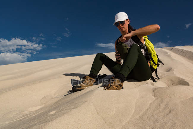 Randonneuse se relaxant sur le sable au désert — Photo de stock