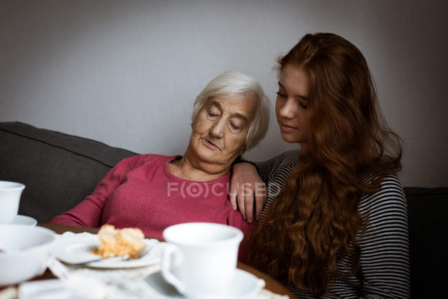 Бабуся і онука взаємодіють у вітальні — стокове фото