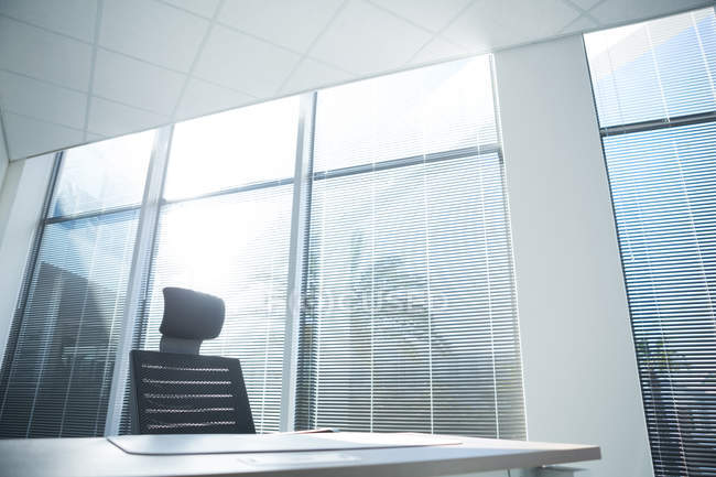 Empty chair and desk in office on a sunny day — Stock Photo