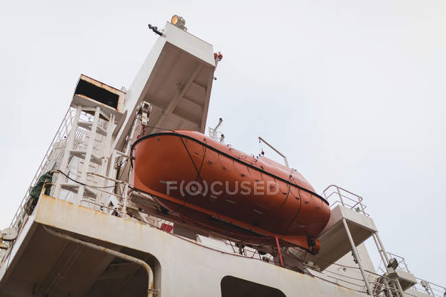 Vue à angle bas d'une embarcation de sauvetage et d'une embarcation de sauvetage suspendues sur un côté d'un navire — Photo de stock