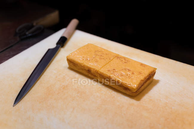 Сырный блок хранится на доске для рубки в ресторане — стоковое фото