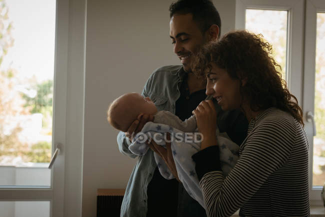 Родители держат ребенка в гостиной дома — стоковое фото