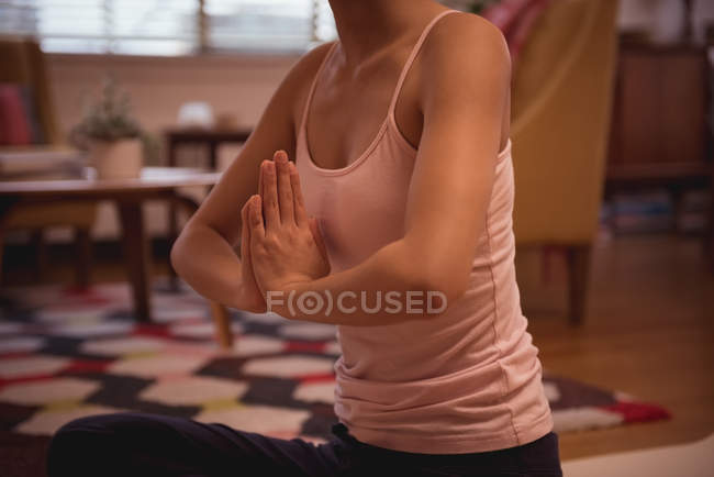 Жінка, що виконує йогу у вітальні вдома — стокове фото