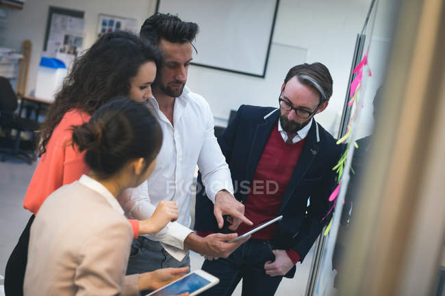 Executives discussing over digital tablet in modern office — Stock Photo