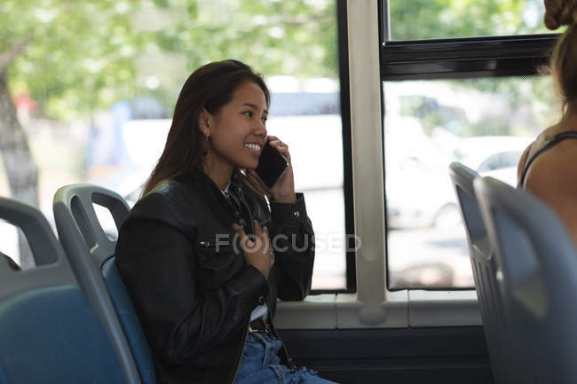 Дівчина-підліток розмовляє на мобільному телефоні в автобусі — стокове фото
