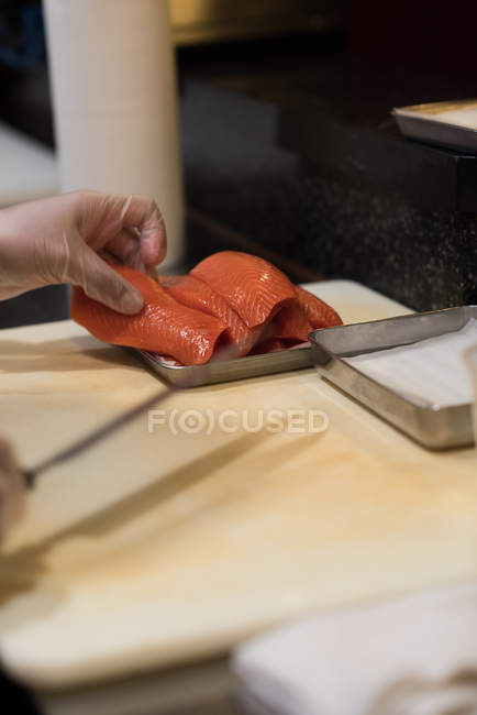 Chef filettatura di pesce nella cucina del ristorante su un tagliere — Foto stock