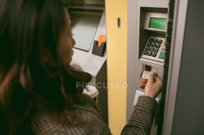 Женщина берет билет из автомата на железнодорожной платформе — стоковое фото