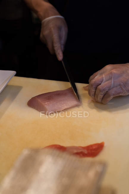 Chef filetagem de peixe na cozinha do restaurante em uma tábua de cortar — Fotografia de Stock