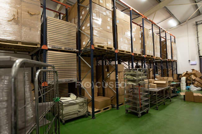 Scatole di cartone in scaffale in fabbrica vuota — Foto stock