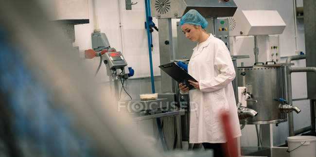 Trabalhadora feminina que verifica o peso dos alimentos no mchine — Fotografia de Stock