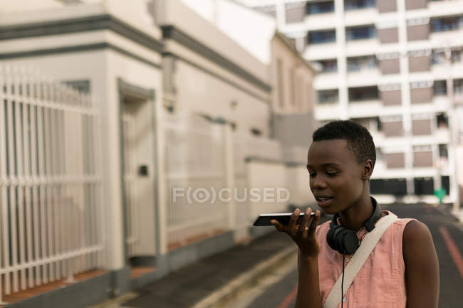 Woman talking on mobile phone in city street — Stock Photo