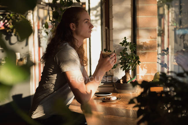 Thoughtful man having coffee in cafeteria — Stock Photo