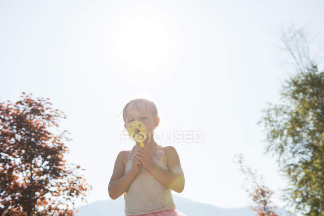 Menina bonito jogando com varinha de bolha no parque — Fotografia de Stock