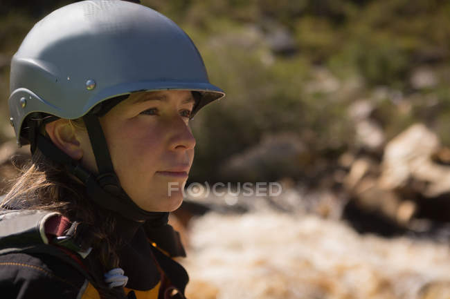 Retrato de kayak femenino en casco protector por río
. - foto de stock