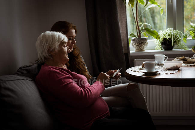 Nonna e nipote guardando la fotografia in soggiorno — Foto stock