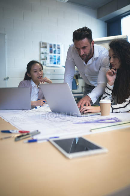 Dirigenti che lavorano su computer portatile in ufficio moderno — Foto stock