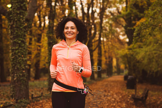 Femme jogging en forêt pendant la saison de l'autum — Photo de stock