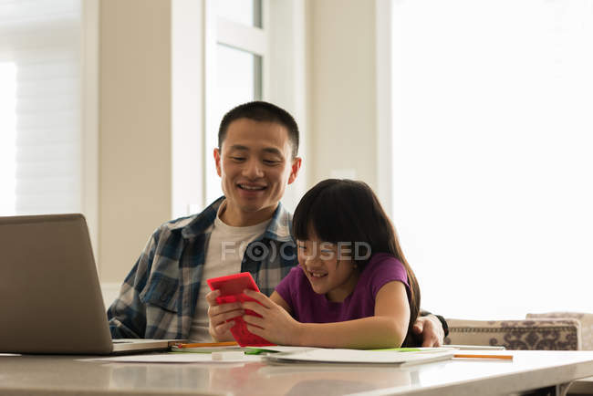 Девочка играет в видеоигры со своим отцом дома — стоковое фото