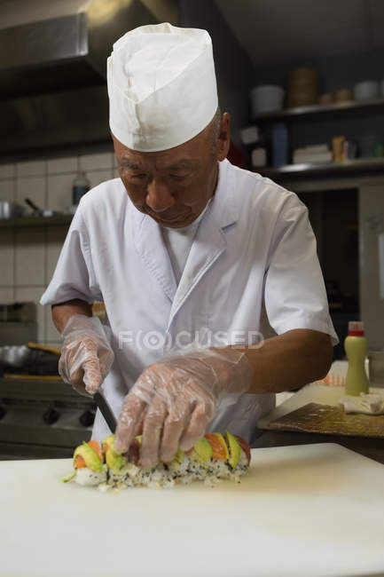 Jefe de cocina preparando sushi en la cocina del hotel - foto de stock