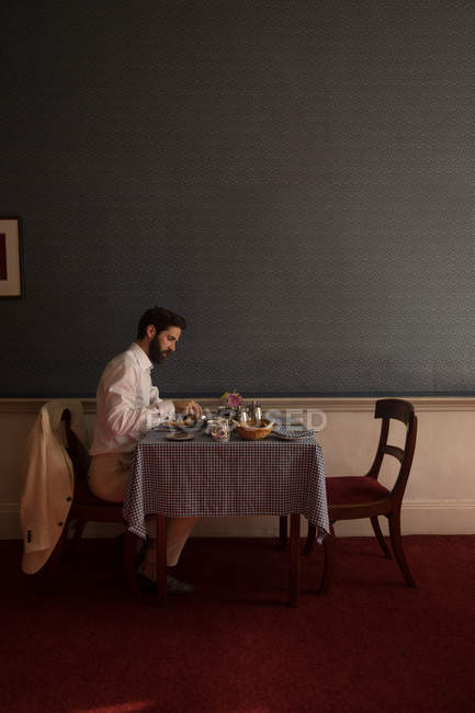 Side view of groom having his meal at home — Stock Photo
